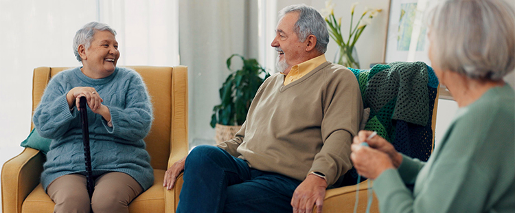 Several seniors sit together and chat in a comfortable room at a senior living community in Austell.